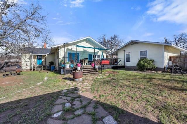 back of house featuring a lawn and a wooden deck