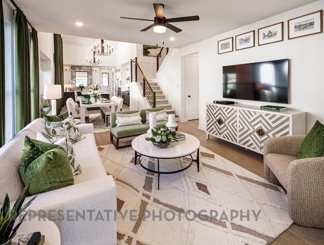 living room with recessed lighting, stairway, ceiling fan with notable chandelier, and wood finished floors