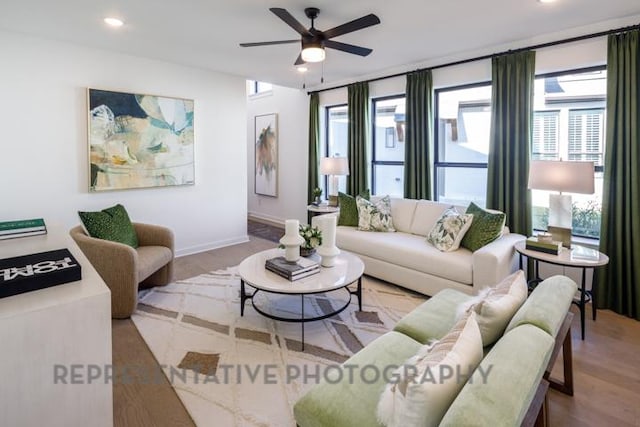 living room featuring ceiling fan, baseboards, wood finished floors, and recessed lighting