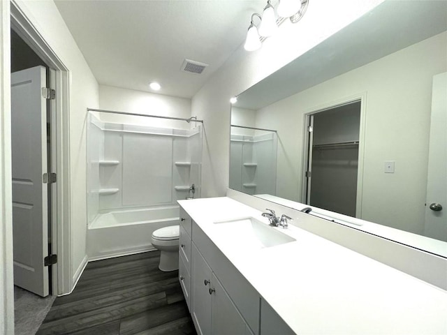 bathroom featuring visible vents, toilet, shower / washtub combination, wood finished floors, and vanity