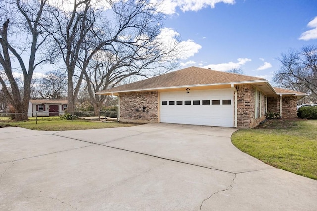 view of side of home featuring a lawn, driveway, fence, roof with shingles, and an attached garage