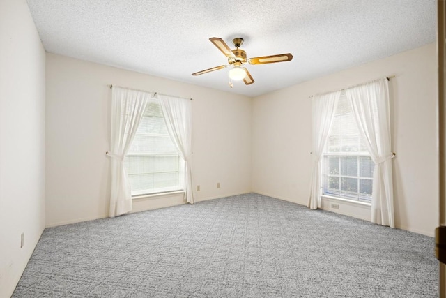 empty room with carpet flooring, a textured ceiling, and ceiling fan