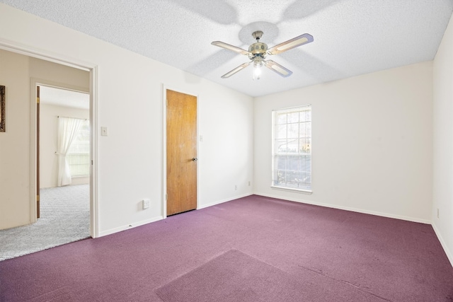 carpeted spare room with a textured ceiling, baseboards, and ceiling fan