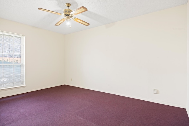 spare room featuring baseboards, ceiling fan, and dark colored carpet