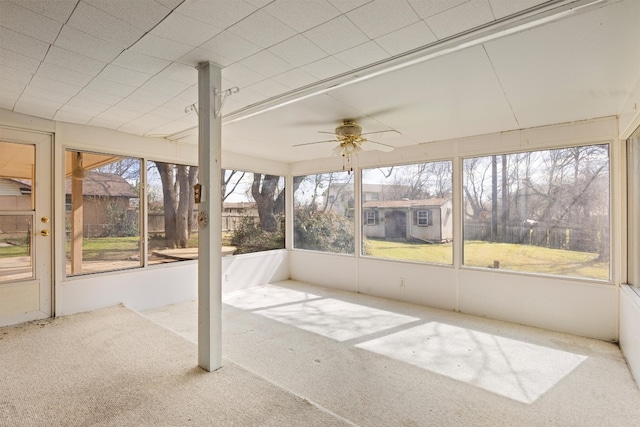 unfurnished sunroom with ceiling fan