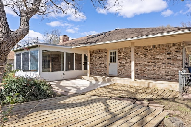 back of house with a patio, brick siding, a chimney, and a sunroom