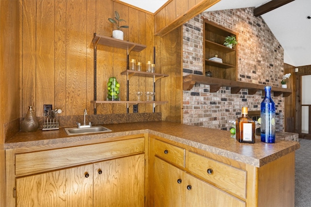 kitchen featuring open shelves, a sink, carpet, wood walls, and vaulted ceiling with beams