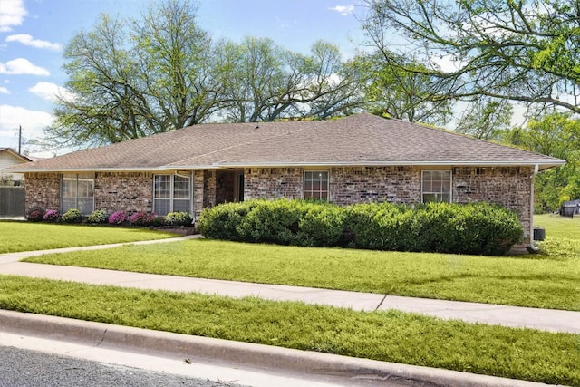 ranch-style home featuring a front yard, brick siding, and a shingled roof