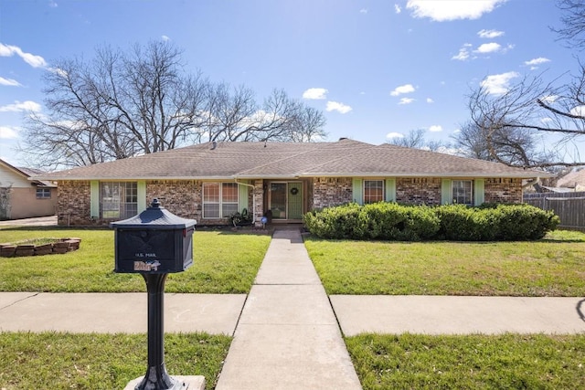 ranch-style house featuring a front yard, fence, brick siding, and roof with shingles