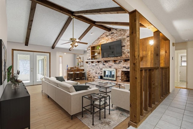 living room featuring vaulted ceiling with beams, french doors, light wood-style floors, a textured ceiling, and a ceiling fan