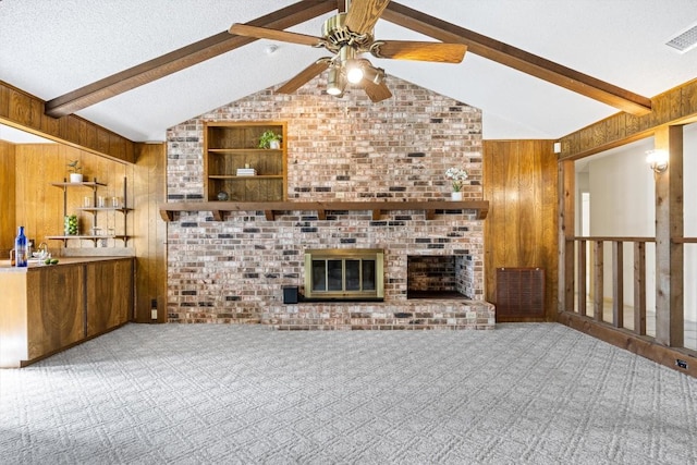 unfurnished living room featuring wooden walls, vaulted ceiling with beams, ceiling fan, and carpet flooring