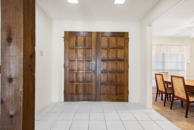 entryway featuring light tile patterned flooring and a textured ceiling