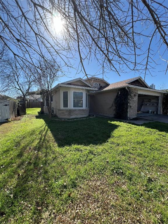 exterior space featuring an attached garage, a front yard, and fence