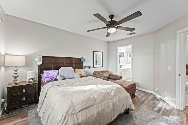 bedroom with wood finished floors, visible vents, baseboards, ceiling fan, and ensuite bathroom