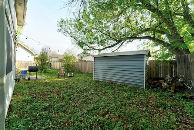 view of yard with a storage shed, an outbuilding, and a fenced backyard