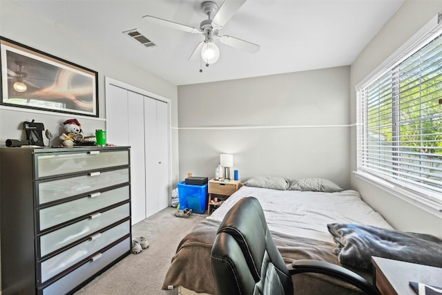 bedroom with a closet, visible vents, a ceiling fan, and carpet floors