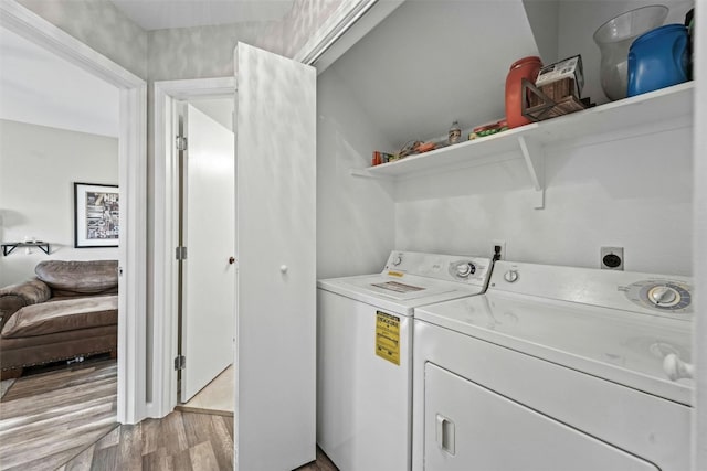 clothes washing area featuring laundry area, light wood-style floors, and separate washer and dryer