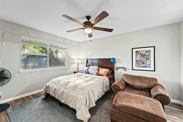 bedroom with a ceiling fan, baseboards, and wood finished floors