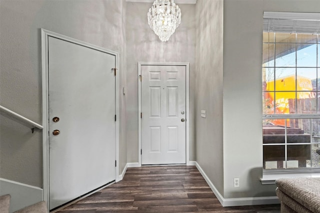 foyer featuring baseboards, a notable chandelier, and dark wood finished floors