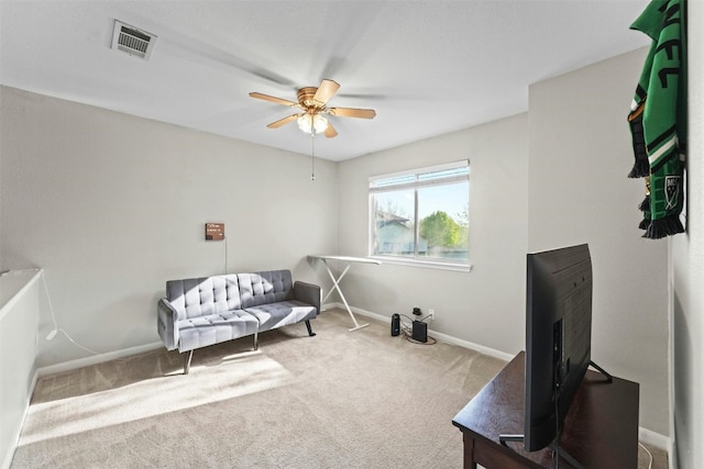 living area with visible vents, baseboards, carpet, and a ceiling fan