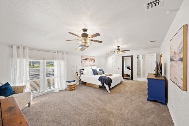 bedroom featuring light colored carpet, visible vents, and a textured ceiling