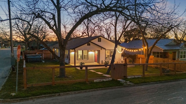 ranch-style home with a standing seam roof, a lawn, a fenced front yard, and metal roof