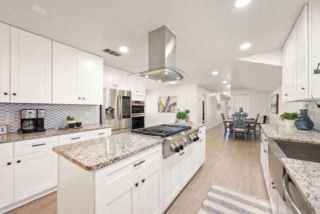 kitchen with range hood, visible vents, stainless steel appliances, decorative backsplash, and light wood-style floors