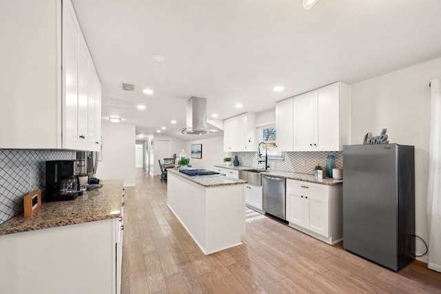 kitchen featuring light wood finished floors, a center island, appliances with stainless steel finishes, island range hood, and white cabinets