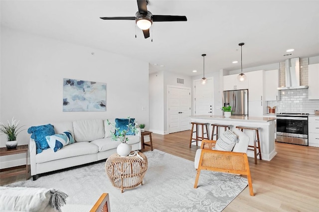 living area featuring visible vents, ceiling fan, baseboards, recessed lighting, and light wood-style floors