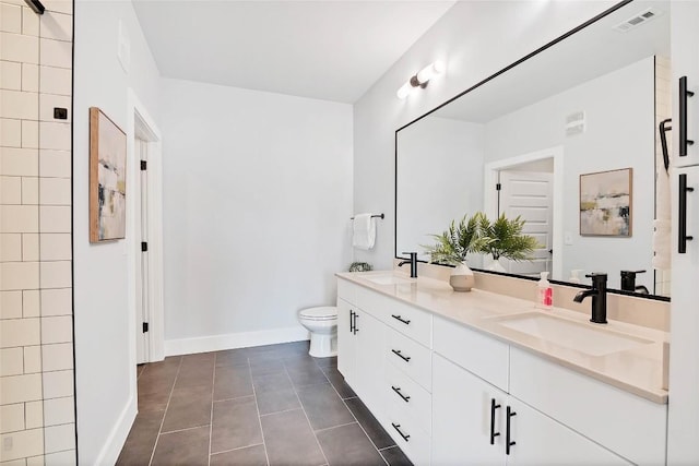 full bath featuring double vanity, visible vents, toilet, and a sink