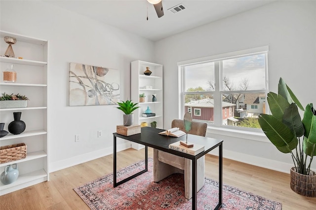 office area featuring visible vents, baseboards, a ceiling fan, and wood finished floors