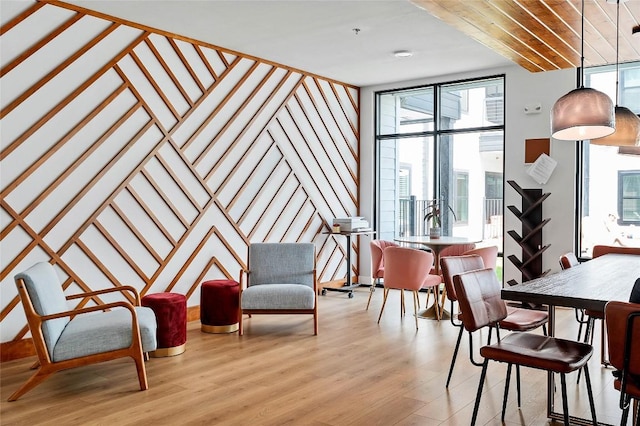 dining space with a healthy amount of sunlight, light wood-type flooring, and expansive windows