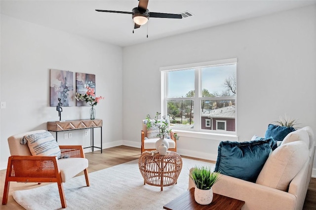 living room with visible vents, baseboards, a ceiling fan, and wood finished floors