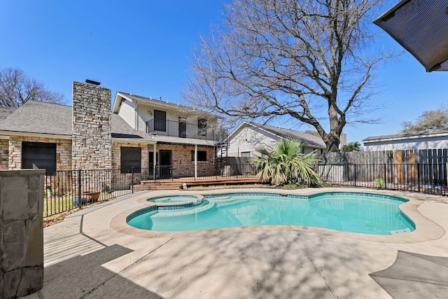 view of pool featuring a patio, fence, and a pool with connected hot tub