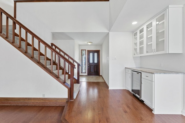 foyer entrance with wine cooler, stairs, baseboards, and dark wood-style flooring