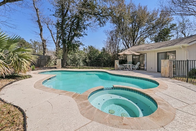 view of swimming pool with a fenced backyard, a pool with connected hot tub, and a patio