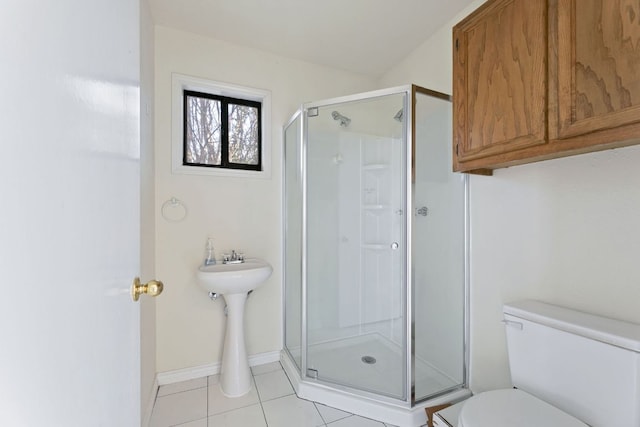 full bathroom featuring tile patterned flooring, toilet, baseboards, and a stall shower