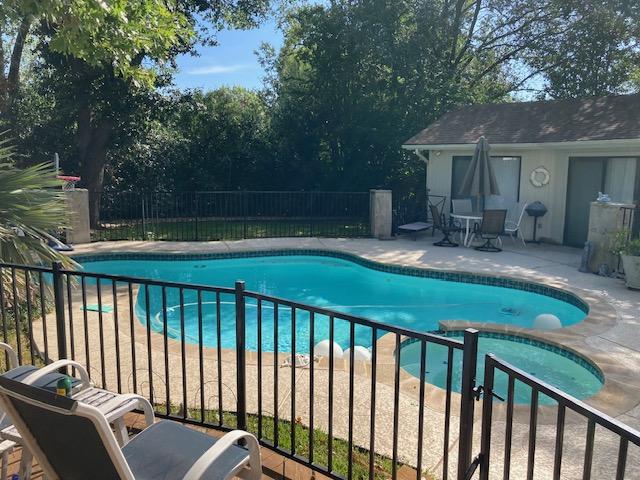 view of swimming pool with a fenced in pool, a patio, an in ground hot tub, and fence