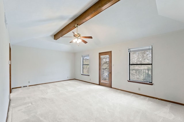 empty room with a ceiling fan, vaulted ceiling with beams, light colored carpet, and baseboards