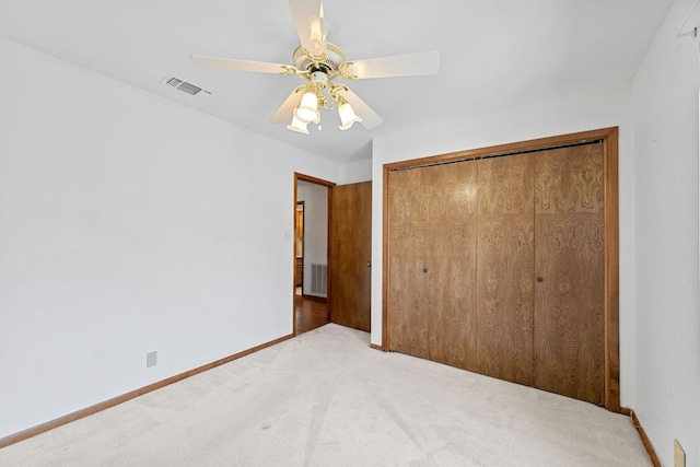 unfurnished bedroom featuring carpet, visible vents, a closet, and baseboards