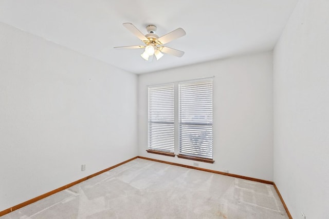 carpeted empty room with baseboards and a ceiling fan