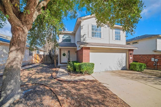 traditional-style house with brick siding, driveway, a garage, and fence