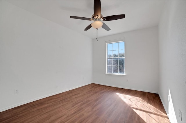 unfurnished room featuring a ceiling fan, wood finished floors, and baseboards