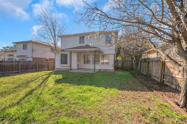 back of property featuring a yard, a patio area, a fenced backyard, and stucco siding