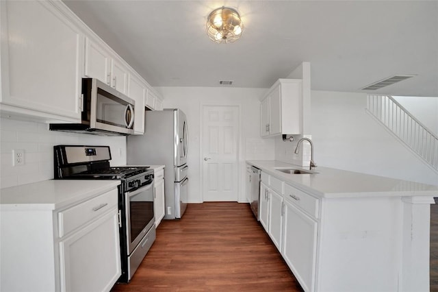 kitchen with a peninsula, visible vents, appliances with stainless steel finishes, and a sink