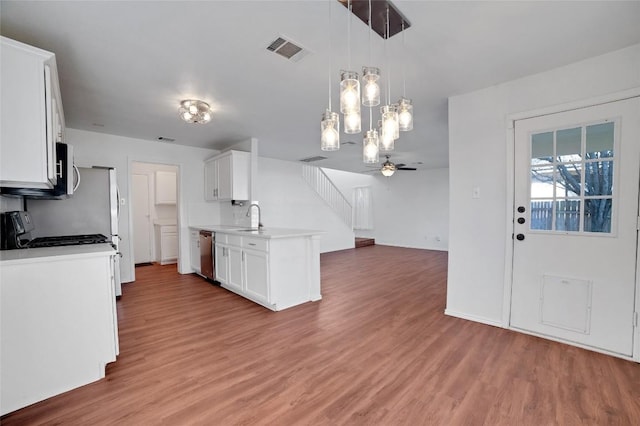 kitchen with visible vents, a sink, open floor plan, stainless steel appliances, and light wood finished floors