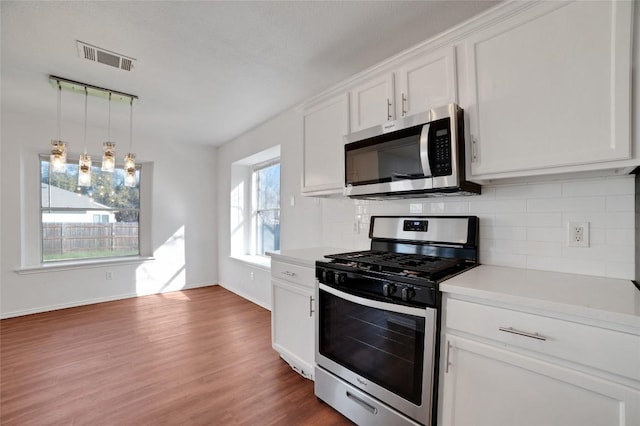 kitchen with visible vents, light countertops, decorative backsplash, appliances with stainless steel finishes, and white cabinets