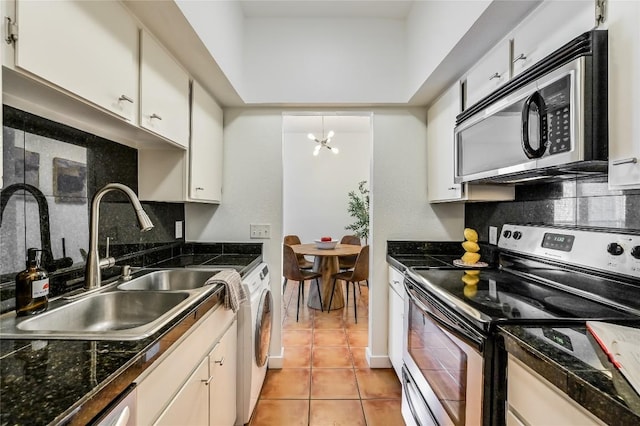 kitchen with a sink, stainless steel appliances, washer / dryer, and decorative backsplash