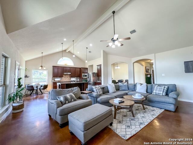 320 Mill Run, New Braunfels, TX 78132 - living room with concrete flooring, beamed ceiling, arched walkways, ceiling fan, and high vaulted ceiling