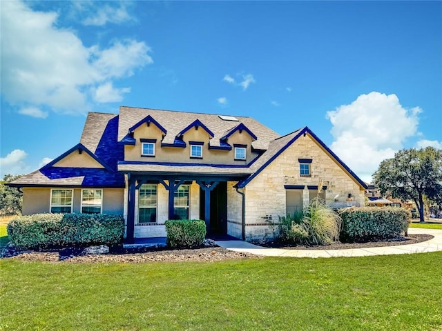 view of front of home with stone siding and a front lawn